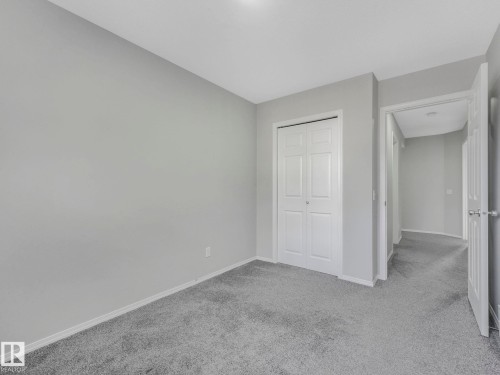 This space features a neutral color palette with light grey walls and light grey carpet - 175 150 Edwards Drive, Edmonton, AB - Indoor Photo Showing Other Room