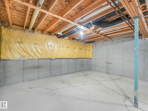The property features an unfinished basement with concrete walls and flooring, exposed wooden ceiling joists, and visible insulation along a wall - 175 150 Edwards Drive, Edmonton, AB - Indoor Photo Showing Basement