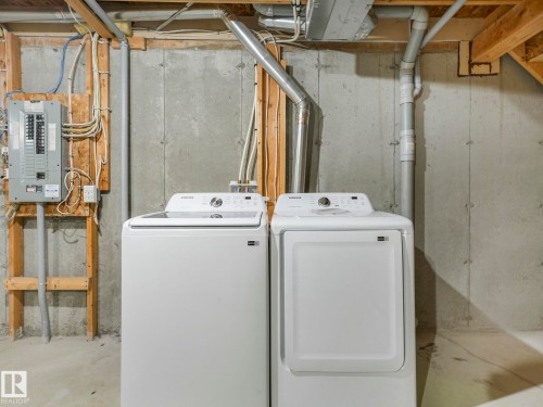 The utility area features a washing machine, a dryer, and a circuit breaker panel - 175 150 Edwards Drive, Edmonton, AB - Indoor Photo Showing Laundry Room