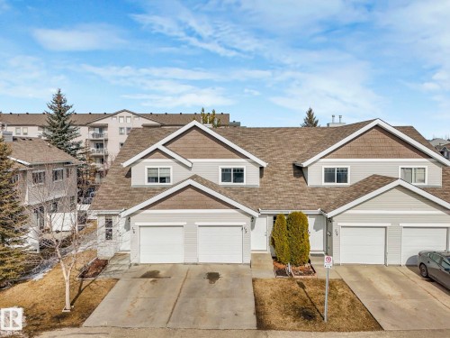 The property features an attached garage with a paved driveway, and a welcoming front entrance - 175 150 Edwards Drive, Edmonton, AB - Outdoor With Facade