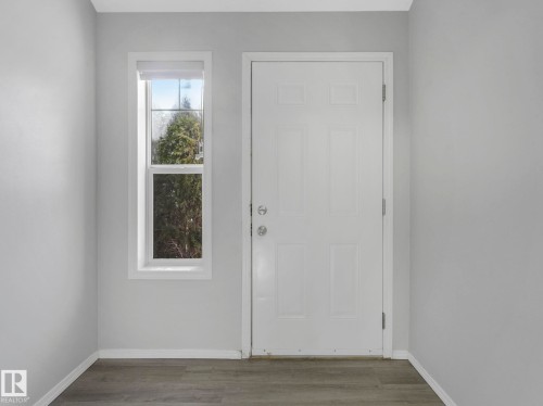 Entryway with a white paneled door, a tall window, and wood-style flooring - 175 150 Edwards Drive, Edmonton, AB - Indoor Photo Showing Other Room