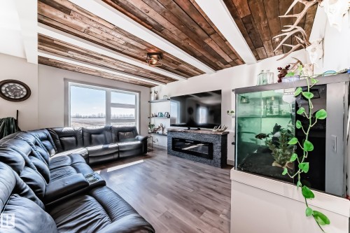 Living area featuring wood-finish flooring and a wood-paneled ceiling with exposed beams - 5263 47 Ave, Calmar, AB - Indoor Photo Showing Living Room