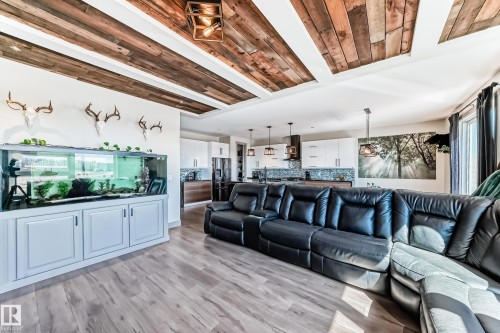 Open-concept interior featuring wood-finish flooring, a decorative wood-paneled ceiling, and recessed lighting - 5263 47 Ave, Calmar, AB - Indoor Photo Showing Living Room