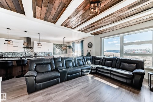 Open-concept living area featuring wood-finish flooring and a coffered ceiling with wood paneling - 5263 47 Ave, Calmar, AB - Indoor Photo Showing Living Room