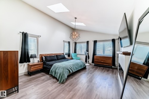 Spacious bedroom featuring vaulted ceilings, two skylights, and wood-finish flooring - 5263 47 Ave, Calmar, AB - Indoor Photo Showing Bedroom