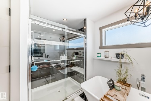 Spacious bathroom featuring a glass-enclosed shower with gray tiled walls and a built-in bench - 5263 47 Ave, Calmar, AB - Indoor