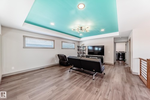 Recessed ceiling with a vibrant accent color and contemporary chandelier lighting - 5263 47 Ave, Calmar, AB - Indoor