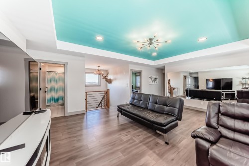 Recessed ceiling with a vibrant turquoise paint finish and a modern sputnik light fixture - 5263 47 Ave, Calmar, AB - Indoor Photo Showing Living Room