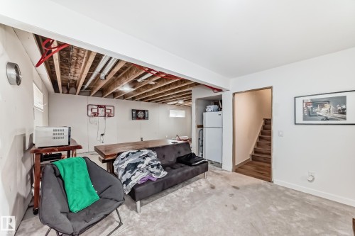 Spacious lower level offering a large open area, recessed lighting, exposed ceiling joists, and a partial wood-finish staircase - 5263 47 Ave, Calmar, AB - Indoor Photo Showing Other Room