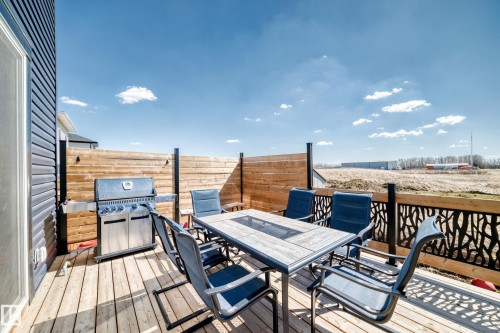 Wood deck featuring a black metal decorative railing, horizontal wood privacy screening, and dark siding - 5263 47 Ave, Calmar, AB - Outdoor With Deck Patio Veranda