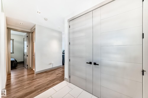 Hallway featuring wood-finish flooring, white walls, recessed lighting, and a double-door closet with matte black hardware - 5263 47 Ave, Calmar, AB - Indoor Photo Showing Other Room