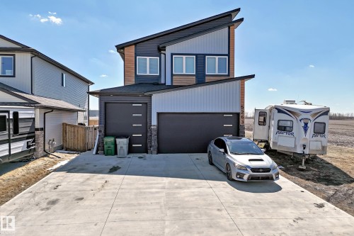 Contemporary architectural exterior featuring multiple cladding materials, a double attached garage, and a concrete driveway - 5263 47 Ave, Calmar, AB - Outdoor With Exterior