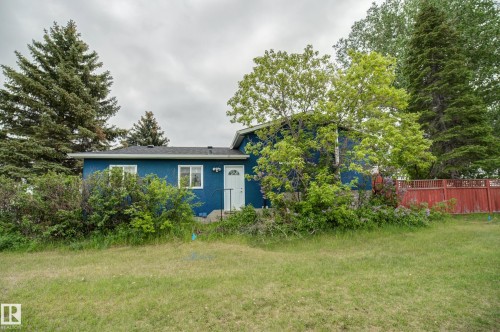 Blue exterior with white trim windows and a white entry door - 4823 10 Avenue, Edmonton, AB 