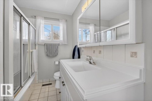 Bathroom featuring a white vanity with integrated sink, chrome faucet, and a wall-mounted mirrored medicine cabinet - 13508 81 Street, Edmonton, AB - Indoor Photo Showing Bathroom