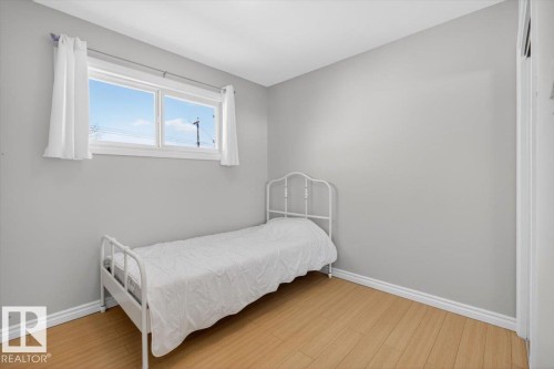 Room featuring light gray walls, wood-finish flooring, and white baseboards - 13508 81 Street, Edmonton, AB - Indoor Photo Showing Bedroom