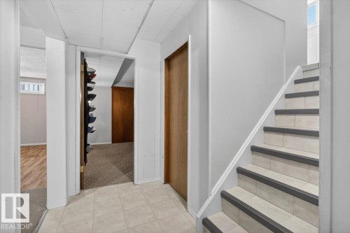 Tiled staircase with safety treads and a white handrail - 13508 81 Street, Edmonton, AB - Indoor Photo Showing Other Room