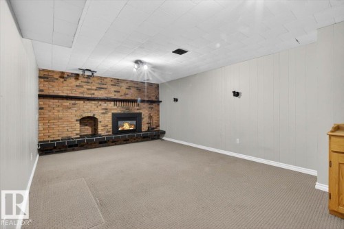 Expansive room featuring a brick fireplace with a raised hearth - 13508 81 Street, Edmonton, AB - Indoor With Fireplace