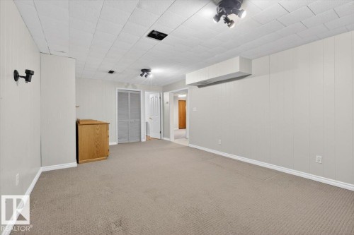 Spacious room featuring carpeting, paneled walls, and a drop ceiling with track lighting - 13508 81 Street, Edmonton, AB - Indoor Photo Showing Other Room