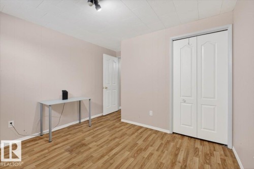 Room featuring wood-finish flooring, light-colored walls, and a white bi-fold closet door - 13508 81 Street, Edmonton, AB - Indoor Photo Showing Other Room