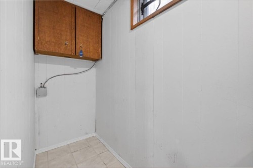 Paneling walls with wood-finish cabinetry and a single small window - 13508 81 Street, Edmonton, AB - Indoor Photo Showing Other Room