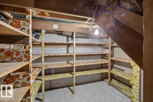 Utility space featuring extensive built-in shelving, exposed wood beams, and a tile floor - 13508 81 Street, Edmonton, AB - Indoor Photo Showing Garage