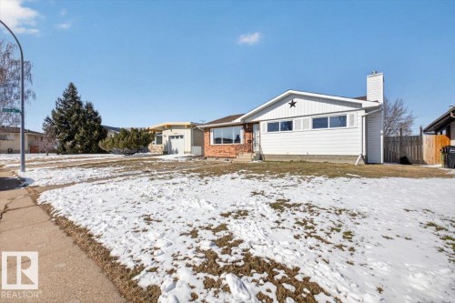 Single-story residence featuring a brick and siding exterior, front-facing bay windows, a prominent chimney, and a concrete sidewalk - 13508 81 Street, Edmonton, AB - Outdoor