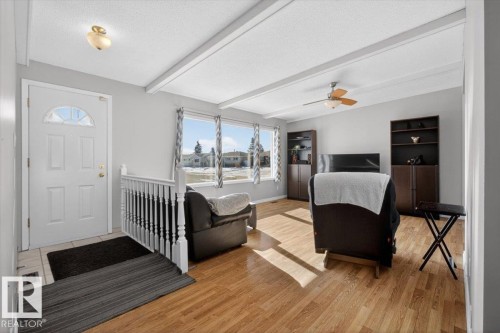 Living area featuring light wood-finish flooring, white exposed ceiling beams, and multiple windows - 13508 81 Street, Edmonton, AB - Indoor