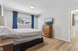 Bedroom featuring light-tone wood-finish flooring and a window with white trim - 