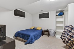 Carpeted room featuring two horizontal windows with internal blinds, a built-in shelving unit, and recessed lighting - 