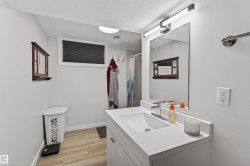 Bathroom featuring a single vanity with an integrated sink, white countertop, and chrome faucet - 