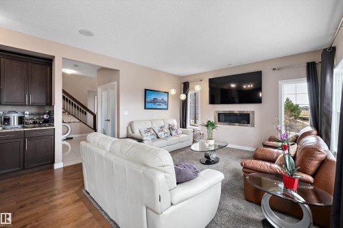 Living area featuring a built-in linear fireplace, recessed lighting, and large windows - 1586 Chapman Way, Edmonton, AB - Indoor Photo Showing Living Room With Fireplace