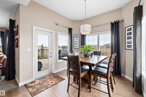 Dining area featuring light wood-finish flooring, neutral-toned walls, and a contemporary drum pendant light fixture - 1586 Chapman Way, Edmonton, AB - Indoor Photo Showing Dining Room