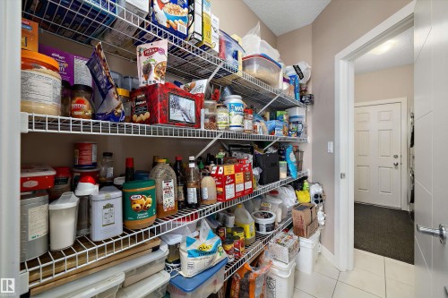 Spacious walk-in pantry featuring multiple levels of wire shelving, neutral wall paint, and white tile flooring - 1586 Chapman Way, Edmonton, AB - Indoor With Storage