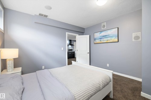 Carpeted sleeping area with light gray walls, white trim, and a white interior door - 1586 Chapman Way, Edmonton, AB - Indoor Photo Showing Bedroom