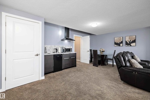 Integrated kitchenette with stone-look backsplash and under-counter refrigeration - 1586 Chapman Way, Edmonton, AB - Indoor