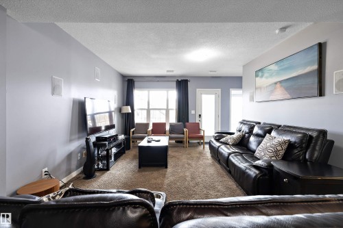 Spacious living area featuring neutral-toned carpeting, light gray walls, and recessed lighting - 1586 Chapman Way, Edmonton, AB - Indoor Photo Showing Living Room