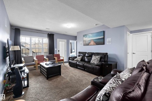 Spacious living area featuring light blue walls and neutral carpet flooring - 1586 Chapman Way, Edmonton, AB - Indoor Photo Showing Living Room