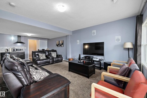 Lower-level recreation space featuring neutral carpeting and light blue walls - 1586 Chapman Way, Edmonton, AB - Indoor Photo Showing Living Room