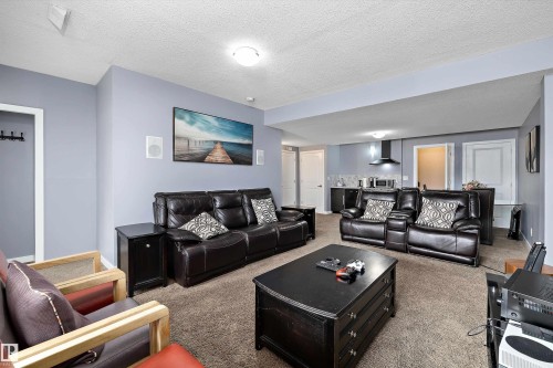 Open-concept living space featuring a built-in wet bar, recessed lighting, and durable carpet flooring - 1586 Chapman Way, Edmonton, AB - Indoor Photo Showing Living Room