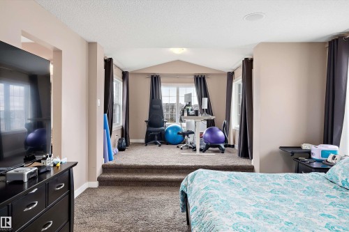 Carpeted interior space featuring a stepped-up, recessed area with multiple windows, recessed ceiling lighting, and a built-in ceiling speaker - 1586 Chapman Way, Edmonton, AB - Indoor Photo Showing Bedroom