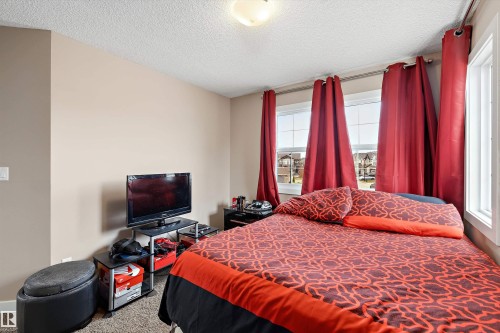 Bedroom featuring large windows, neutral wall tones, and textured carpeting - 1586 Chapman Way, Edmonton, AB - Indoor Photo Showing Bedroom