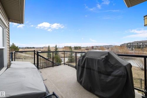Spacious outdoor deck featuring carpeted flooring and black metal railings with glass panels - 1586 Chapman Way, Edmonton, AB - Outdoor With Exterior