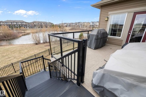 Exterior deck featuring a concrete surface, black aluminum railing with glass panels, and a staircase leading to the yard - 1586 Chapman Way, Edmonton, AB - Outdoor With Exterior