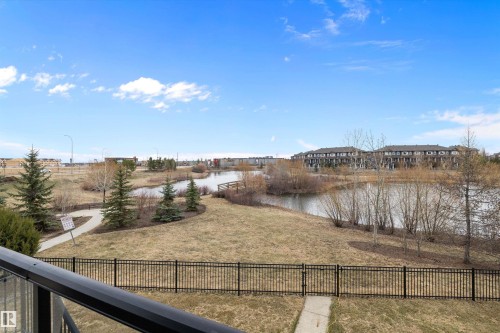 Pond and parkland scenery from a balcony with a black metal railing - 1586 Chapman Way, Edmonton, AB - Outdoor With View