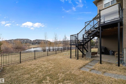 Rear exterior featuring a black metal deck and staircase with glass panel railings - 1586 Chapman Way, Edmonton, AB - Outdoor