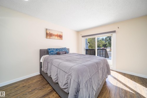Wood-finish flooring throughout, complemented by light-toned wall finishes and white baseboards - 5303 21 Avenue, Edmonton, AB - Indoor Photo Showing Bedroom