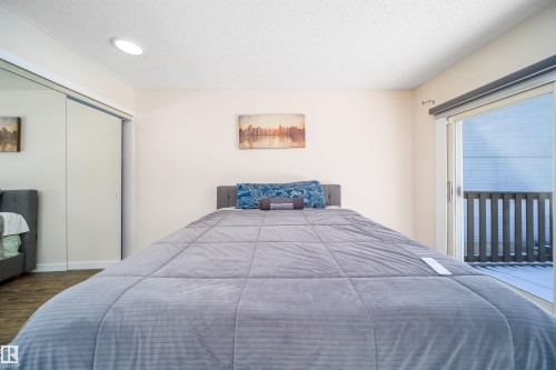 Bedroom featuring wood-finish flooring, recessed lighting, and a sliding glass door providing outdoor access - 5303 21 Avenue, Edmonton, AB - Indoor Photo Showing Bedroom