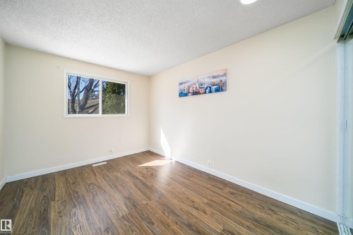 Room featuring wood-finish flooring, white baseboards, and neutral wall paint - 5303 21 Avenue, Edmonton, AB - Indoor Photo Showing Other Room