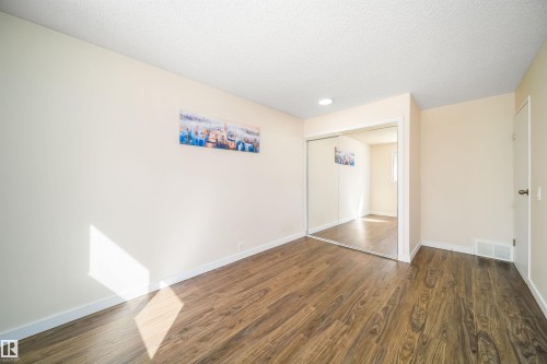 Room featuring wood-finish flooring, light-toned wall paint, and white trim - 5303 21 Avenue, Edmonton, AB - Indoor Photo Showing Other Room