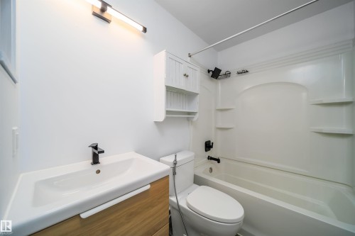 Bathroom featuring a white vanity with a wood-finish base, a rectangular basin, and a matte black faucet - 5303 21 Avenue, Edmonton, AB - Indoor Photo Showing Bathroom